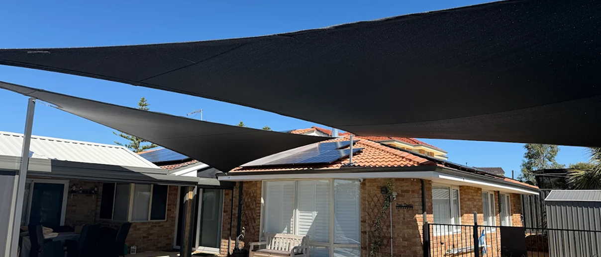 A tensioned shade sail against a clear sky